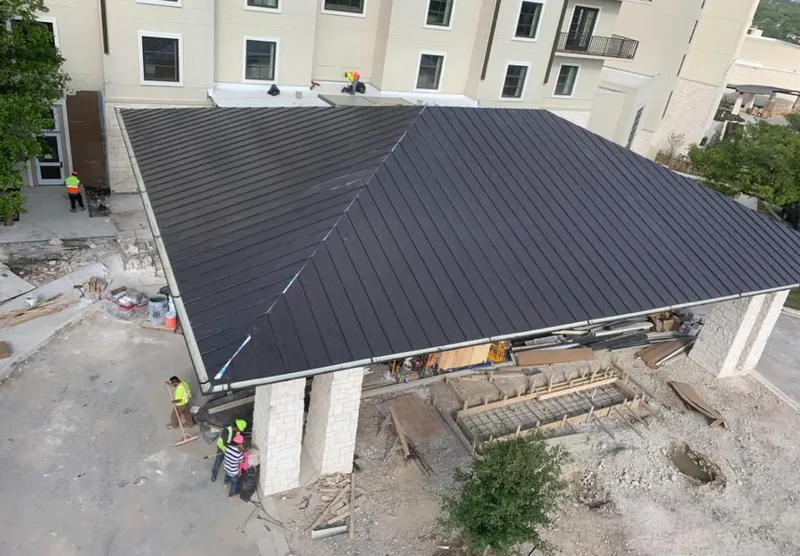 Metal roofing installation team working on a commercial building in Nederland
